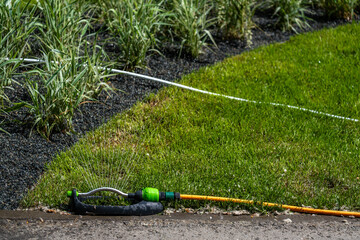 Watering the green lawns in the park on a summer day.
