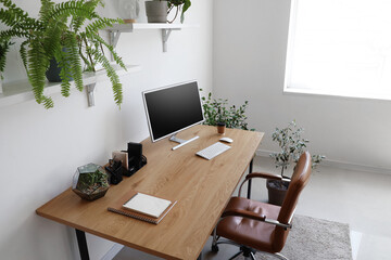 Interior of office with workplace, shelves and green houseplants
