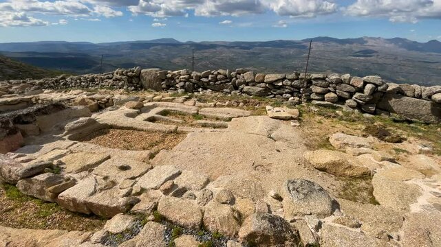 We see an archaeological area restored and cleaned with gray gravel where we see 2 anthropomorphic tombs from the 7th century Visigothic period and some rows of stones forming walls we see a valley