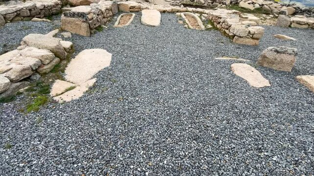 We see an archaeological area restored and cleaned with dark gray gravel where we see 2 anthropomorphic tombs from the Visigoth period and some rows of stones forming walls. There is a valley