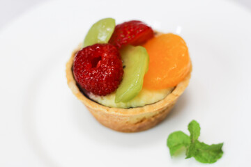 selective focus of mini fruit pie on white plate. Isolated. 