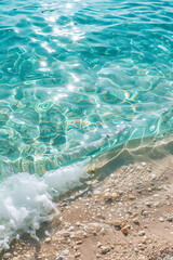 sea water waves texture ripples on water surface light blue ocean water top view clear aqua background sun glow reflection white sand bottom stones underwater tropical island beach