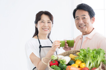 Image of senior citizen in kitchen with health-conscious green juice (drink) Close-up looking at camera
