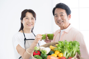 キッチンで健康を気にする青汁(飲み物)を持ったシニアのヘルスケアのイメージ　クローズアップのカメラ目線