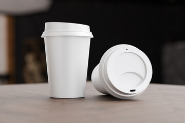 Two white take away coffee cup for mockup presentation branding design rendering minimalist blank close up with moody lighting calm and cozy engaging product display or disposable cup concept