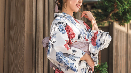 日本家屋の前に立つ浴衣姿の女性