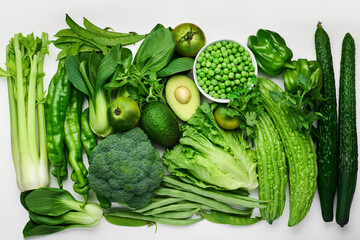 Green vegetables, modern still life, flat lay. Pak choy, broccoli, bitter melon, celery, avocado and various vegetables. Healthy eating concept