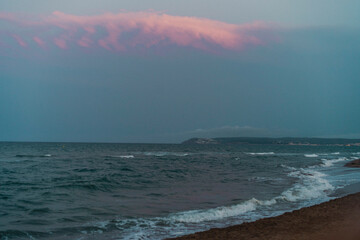 Puesta de sol con nubes rosas en el mar. 