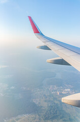 Fototapeta premium View from the airplane window at a beautiful cloudy sky and the airplane wing