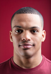 Obraz premium Young man posing showing neutral expression on red background