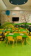 class room of kidergarten. Yellow and green theme based study room for toddlers to learn, play and get educated. tables and chairs are placed inside along with games for kids to play. 
