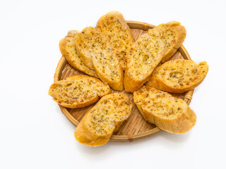 Composition with slices of toasted garlic bread on woven basket and on white background..
