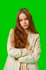 Young Woman Posing in beige Suit against green background