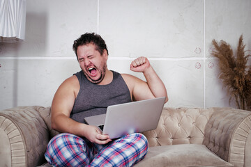A fat lazy man is watching a match at home. Disappointment and gain.