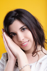 Fototapeta premium Beautiful young woman with long brown hair resting her cheeks on