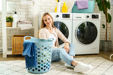 Woman Leaning On Washing Machine In Laundry Room