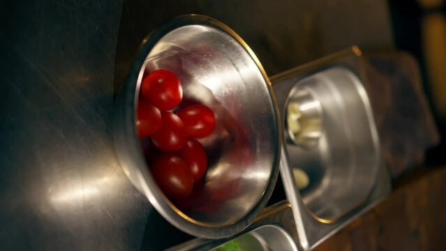 vertical video close-up in restaurant open kitchen kitchen paraphernalia lies on the iron table preparation for cooking ingredients herb vegetables on table