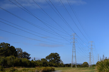 Wide shot Australian overhead high tension high-voltage transmission network power-lines towers...