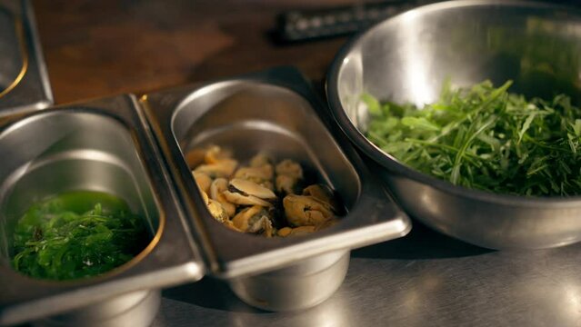 close-up in restaurant open kitchen kitchen paraphernalia lies on the iron table preparation for cooking ingredients herb vegetables on table