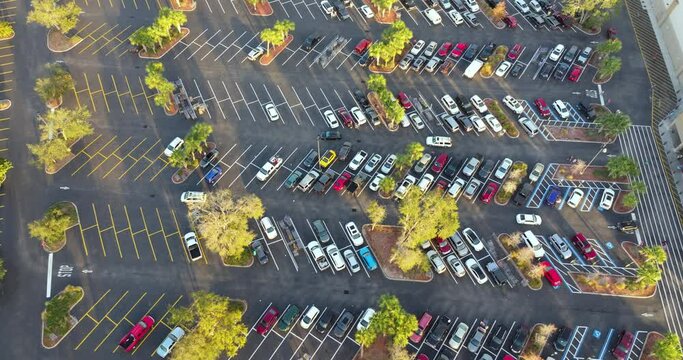 Many parked cars on store parking lot with lines and markings for parking places and directions. Place for vehicles in front of a shopping mall center
