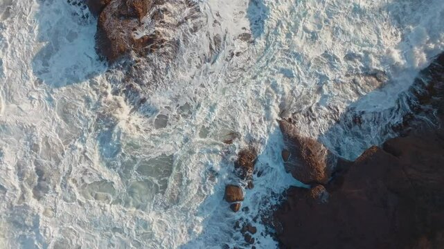 Abstract whitewash of waves crashing over rocks. Piha, Auckland, New Zealand.