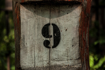 Number 9 in black on an old fence post