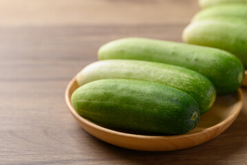 Fresh cucumber on wooden plate, Organic vegetable, Food ingredient