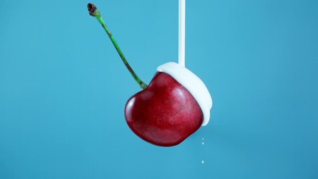 Yogurt Pouring from Top over a cherries blue Background in Slow Motion 1000fps