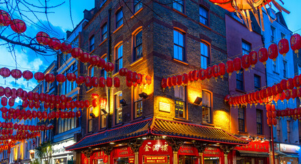 A street corner in Soho's Chinatown with red Chinese lanterns hanging from the walls under a...