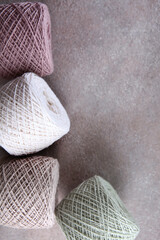 Set of colored cotton yarn. Multicolored balls of yarn for knitting. Handmade work. The concept of a hobby. Skeins of yarn for knitting as a background. Vertical photo.