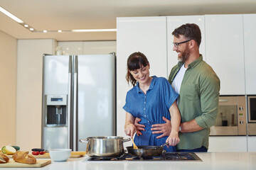 Smile, hug and couple with cooking in kitchen for meal prep, healthy diet and romantic dinner together. Happy, man and woman with food ingredients by stove for marriage, support and nutrition at home