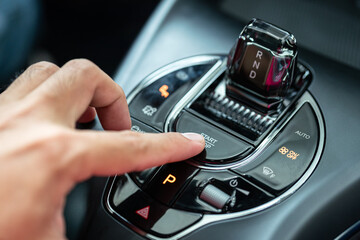 Action of driver finger is pressing on the start button to starting the car engine. Close-up and...