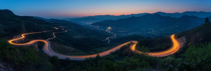 In the serene twilight, an illuminated road curves through misty woodland scenery.