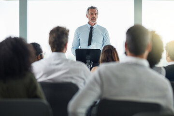 Podium, mature man and advise in seminar, speaker and audience in event, training and presentation...