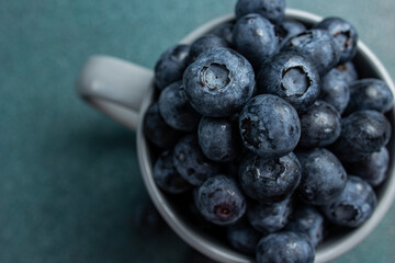 Blueberries in a cup on a dark background. Top view.