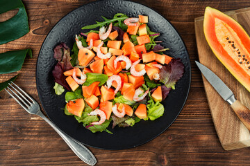 Seafood salad and papaya on a wooden table.
