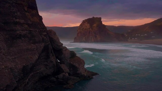 Dreamlike heavenly ocean of waves crassing on the shore at sunset. Piha, Auckland, New Zealand.