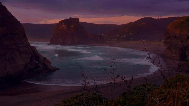 Dreamlike heavenly ocean of waves crassing on the shore at sunset. Piha, Auckland, New Zealand.