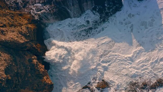 Waves squirting through chutes in rough seas in Piha, Auckland, New Zealand.