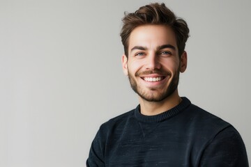 Fototapeta premium A man with a beard and a black sweater is smiling