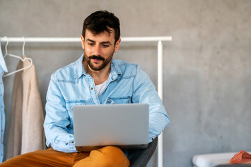 Home office. One smiling man using laptop. Work, freelance, social media, technology concept.