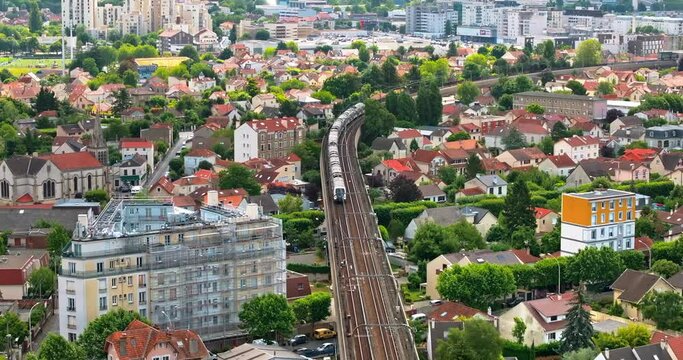 Aerial drone view of Neuilly-Plaisance commune with regional express train in the eastern suburbs of Paris, France