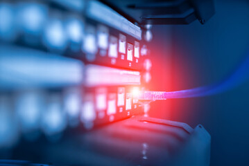 close up of network cables connected to server racks in data center room.