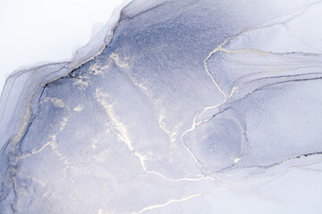 A close-up photograph of a silver and gray ink swirl abstract art piece. The ink swirls create a mesmerizing pattern, with the silver ink adding a subtle sparkle to the piece