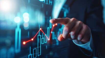 A businessman's hand points to a rising graph on a digital screen, symbolizing growth, success, and financial achievement.