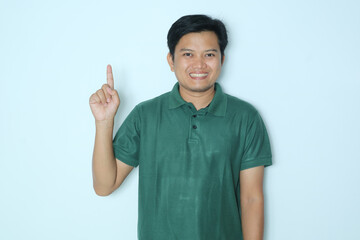 Young Asian man smiling happy and pointing finger right hands up. Wearing red t-shirt