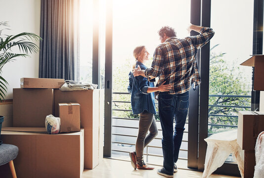 Box, packing and view with couple at door of new home together for property or real estate investment. Love, proud or smile with man and woman moving in at apartment for growth, mortgage or rent - Powered by Adobe
