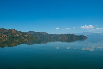 Fototapeta premium reflection of the forest in the lake.Bay views from green forests. View from the forest to the sea. Magnificent views from the forest to the sea. Magnificent bays of Muğla.