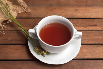 Infusion of plantain, Plantago major, with flowers in the plate on wooden background