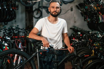Beautiful portrait. Repair man in bicycle shop, working in store